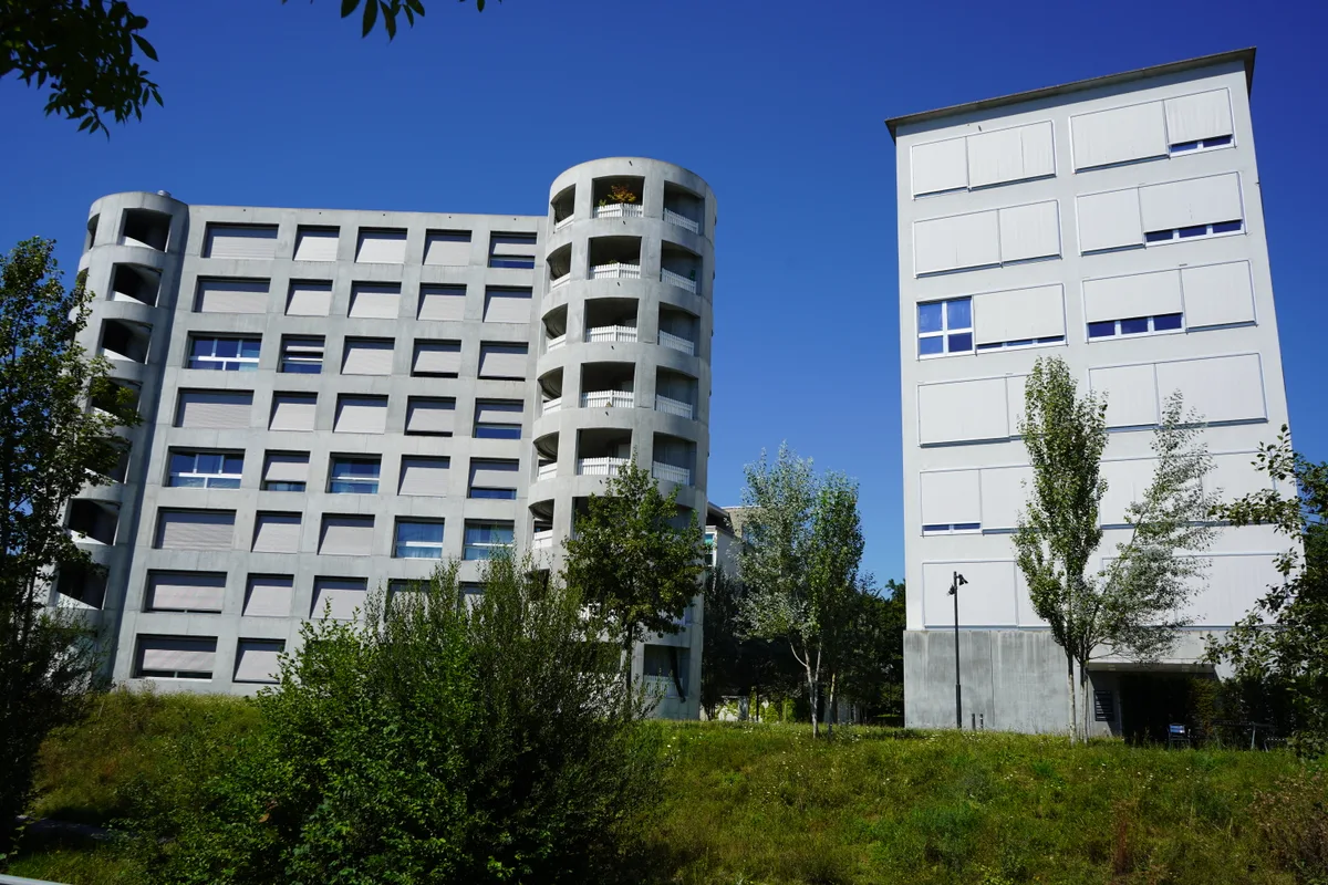 Das Gebäude von Herzog & de Meuron ist aus Beton und hat runde Erker.